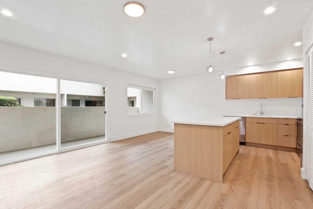 a large living room with a kitchen and a large window