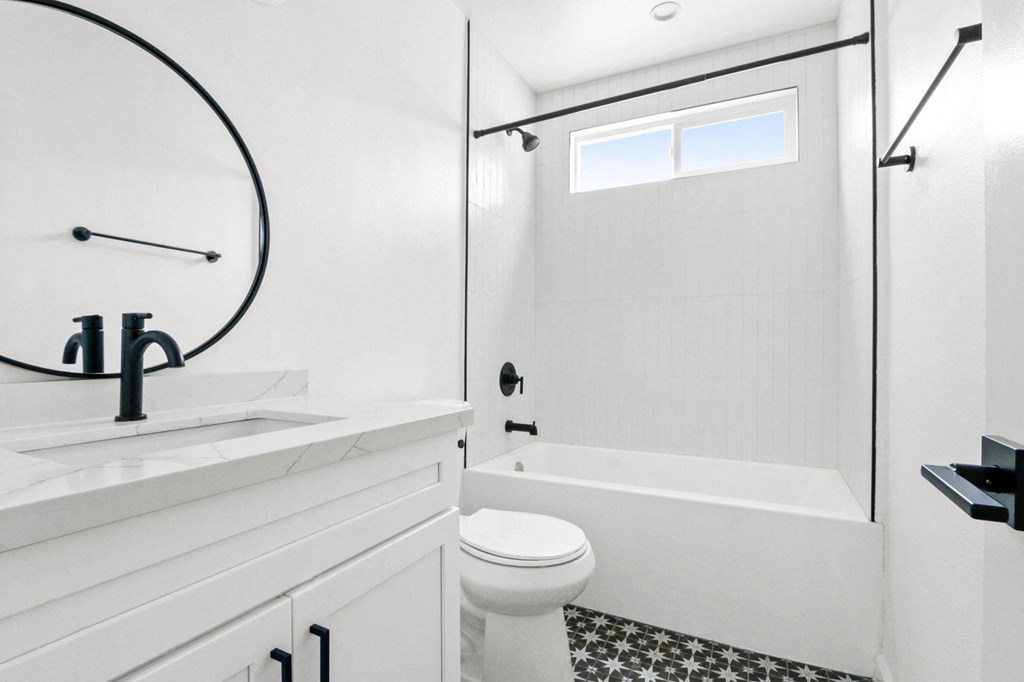 a white bathroom with a tub and a sink and a toilet