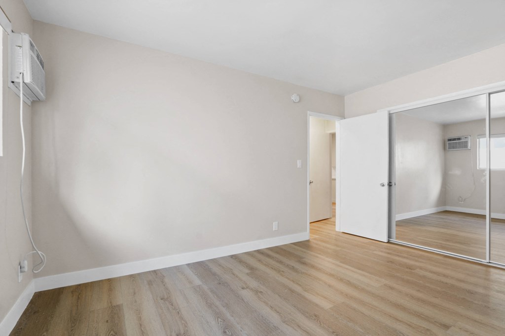 an empty living room with white walls and a sliding glass door