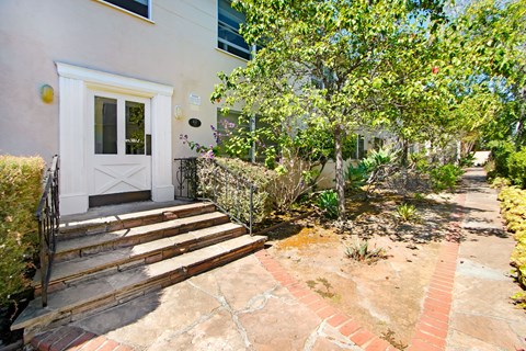 A house with a white door and a small garden in front.