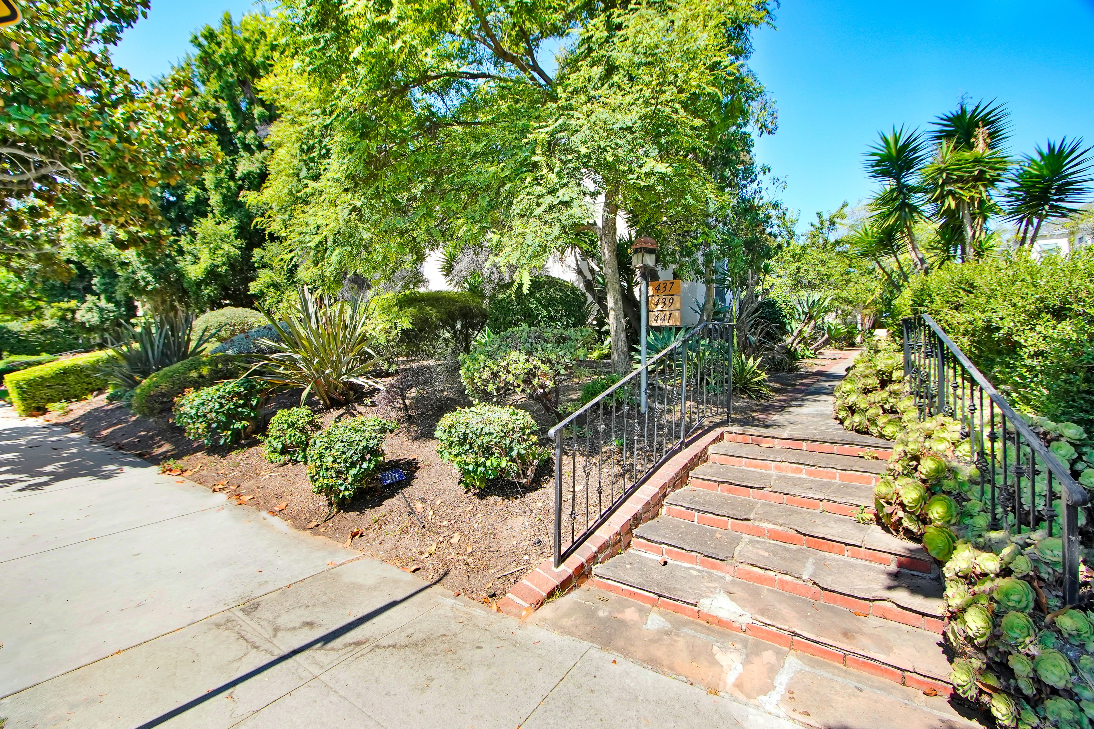 A garden with a staircase and a metal railing.