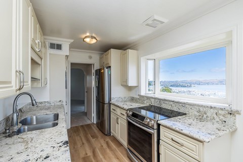 A kitchen with a sink, stove, and refrigerator.