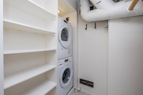 A white washing machine is in a small laundry room.