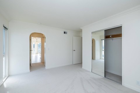 A white room with a mirror and a door.