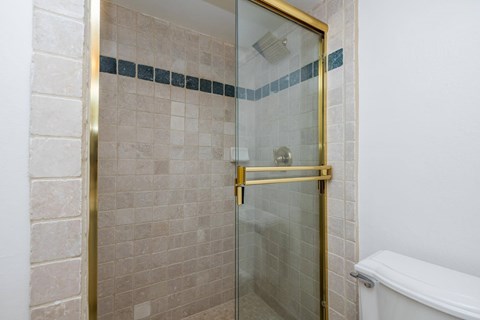 A bathroom with a white tub and a glass shower door.