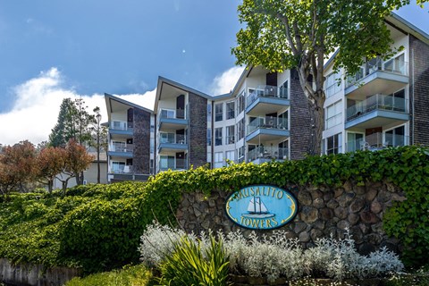 A sign that says Prusalito Towers is in front of a building.