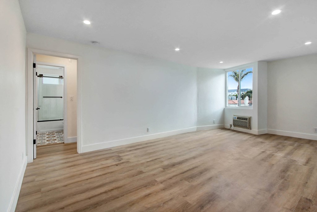 a living room with white walls and wood floors