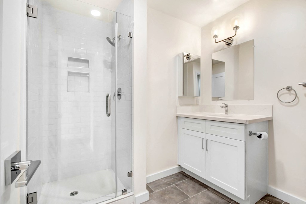 a white bathroom with a shower and a sink