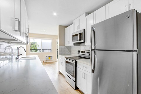a kitchen with stainless steel appliances and white cabinets