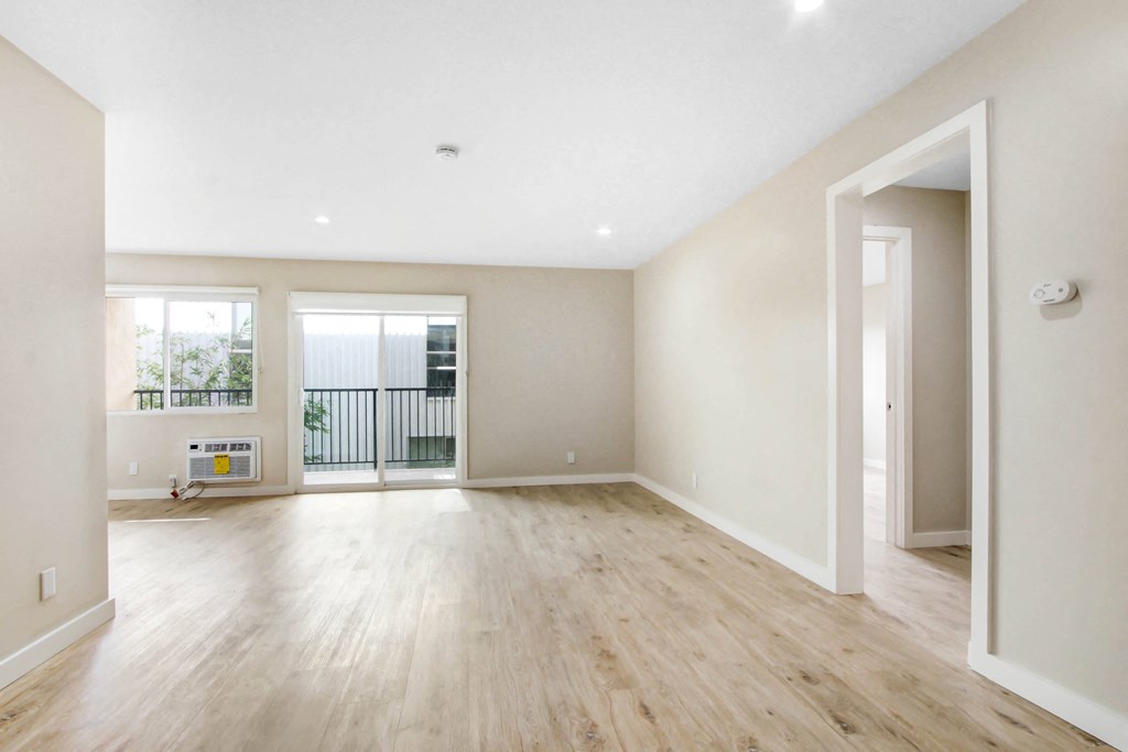 an empty living room with white walls and wood floors