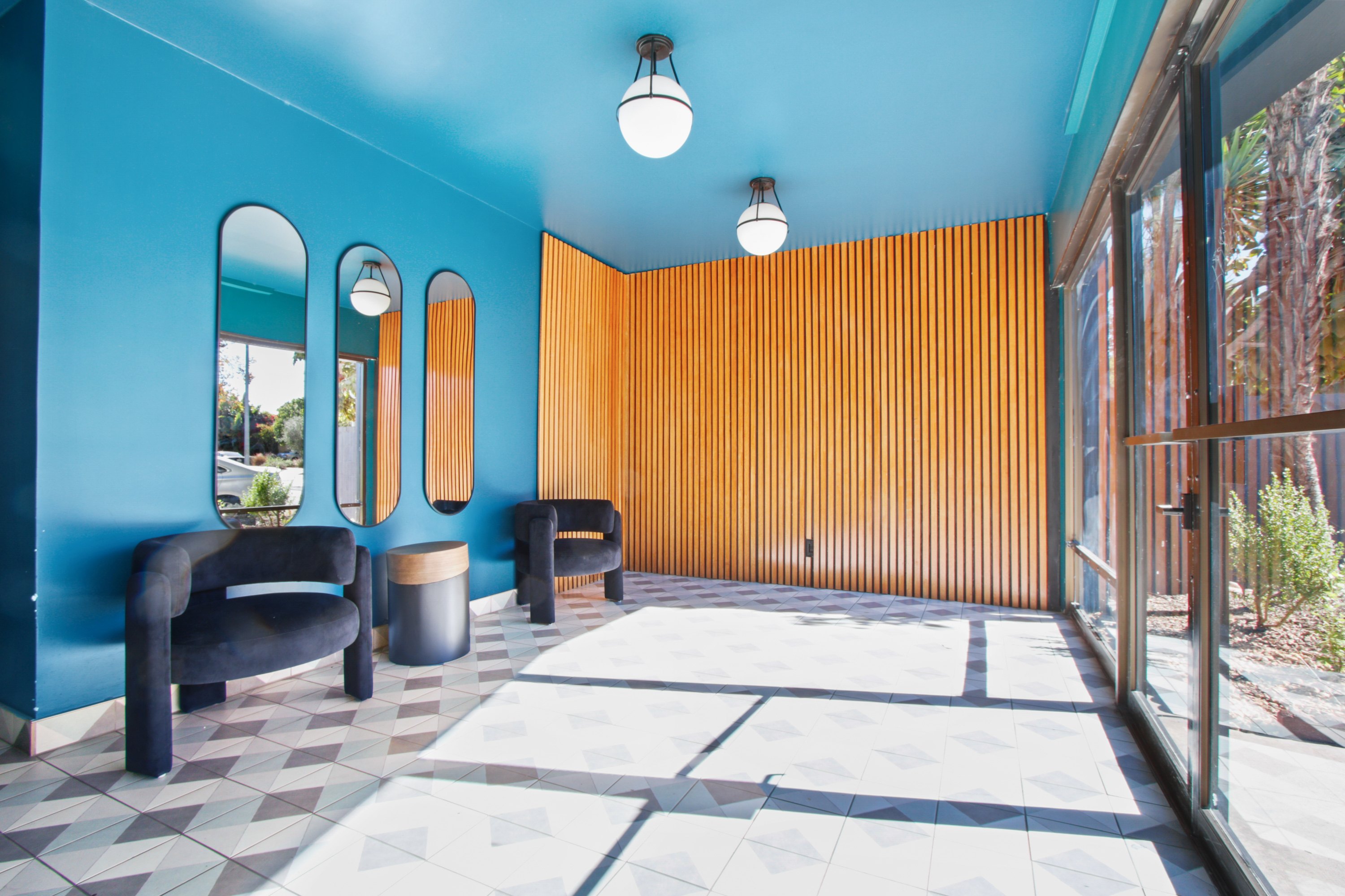 A blue room with a black chair and a brown wall.