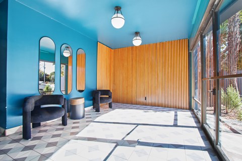 A blue room with a black chair and a brown wall.