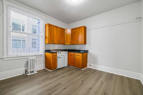 A kitchen with wooden cabinets and a white fridge.