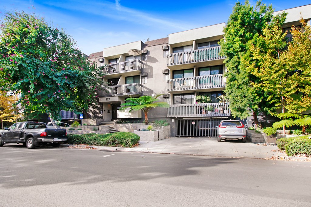 an apartment building with cars parked in front of it