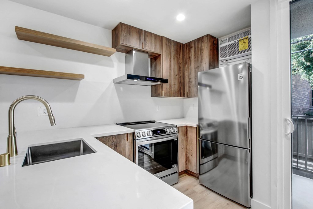 a kitchen with white counter tops and a stainless steel refrigerator