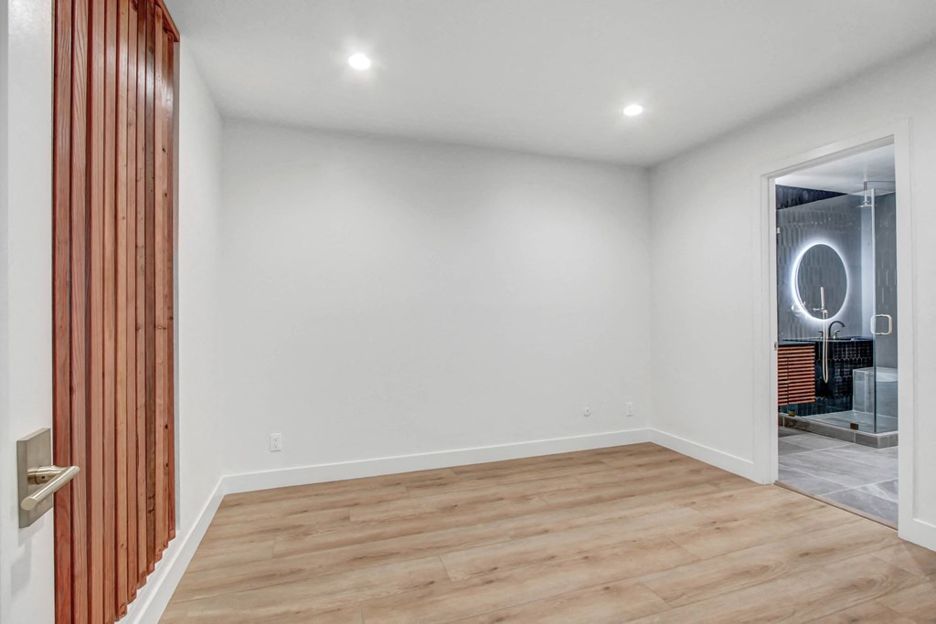 a living room with white walls and a wooden floor