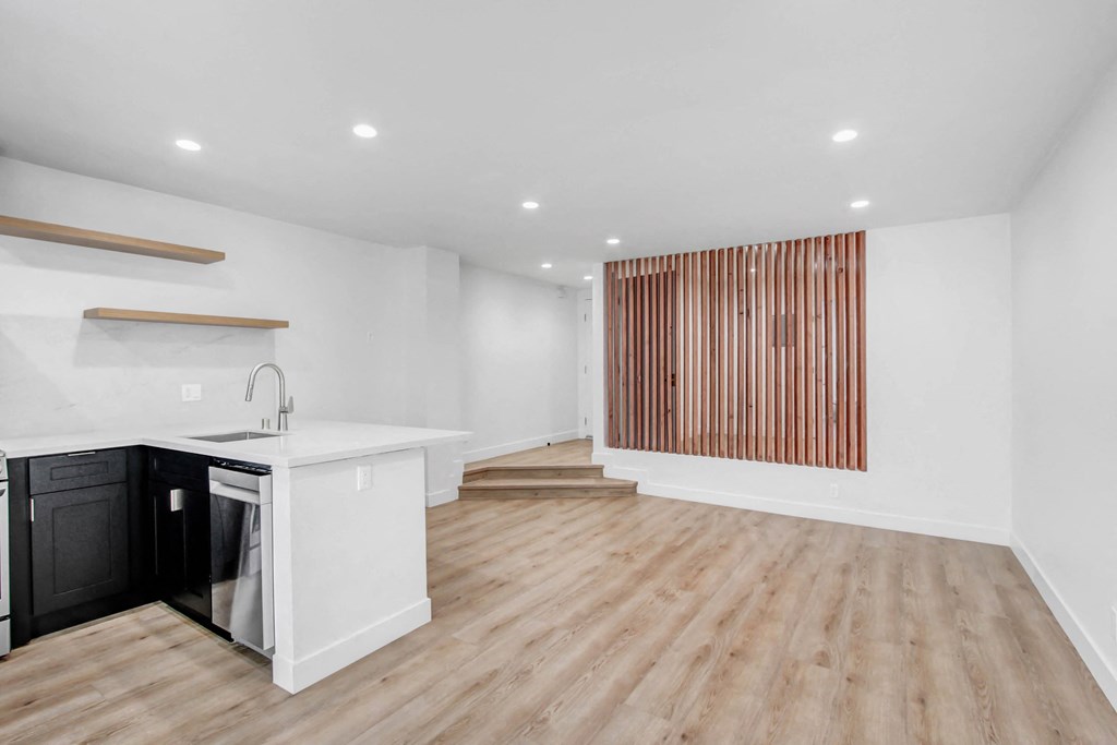 a living room with a kitchen and a staircase