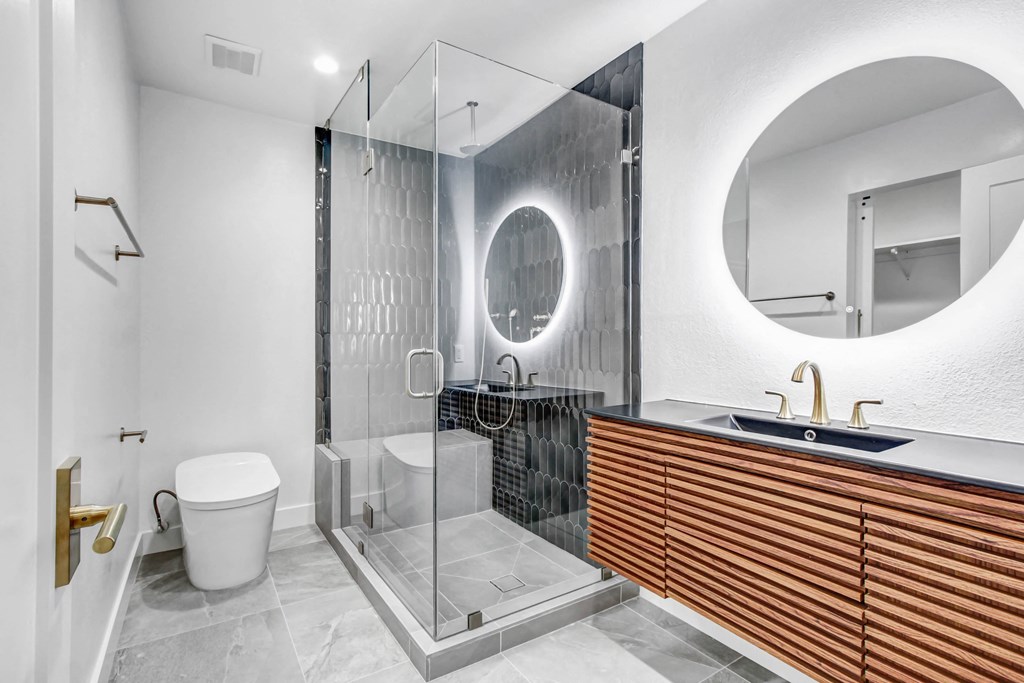 a bathroom with a shower and a sink and a toilet