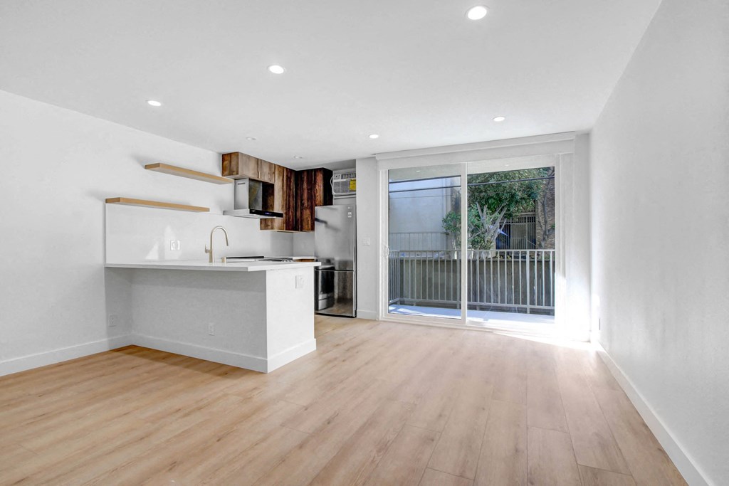 a living room with a kitchen and a sliding glass door