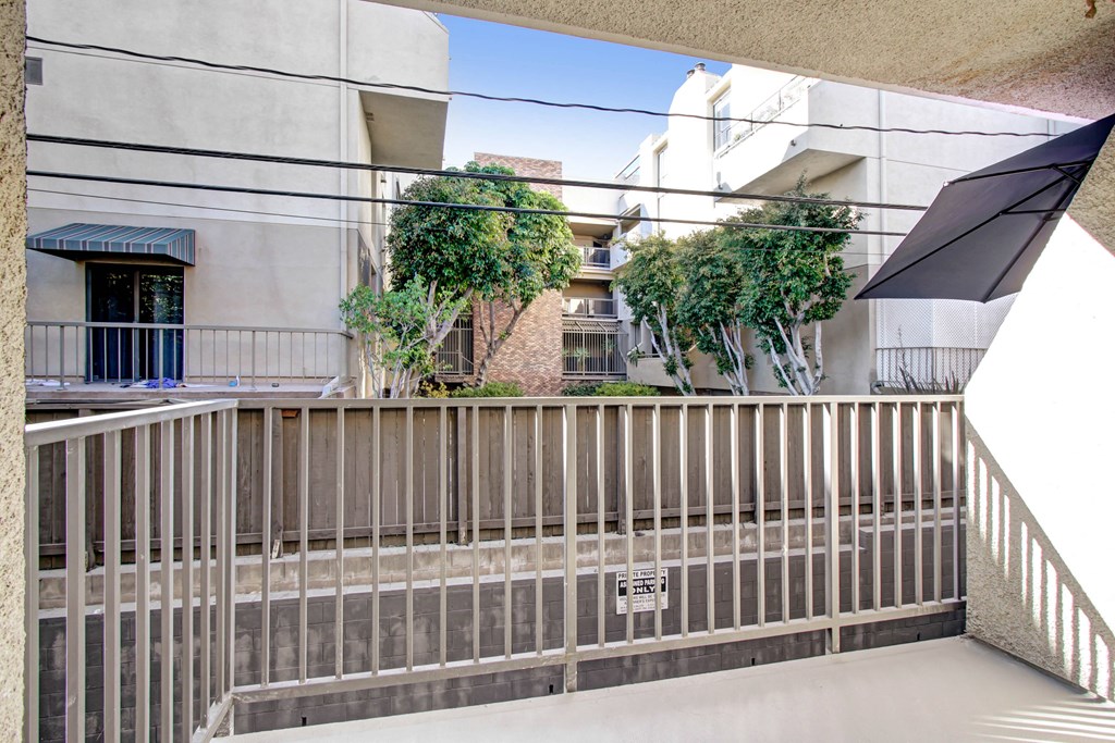 a balcony with a wooden railing and a building in the background