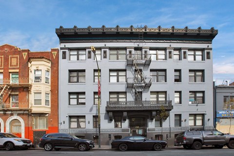 A grey building with a fire escape on the front.