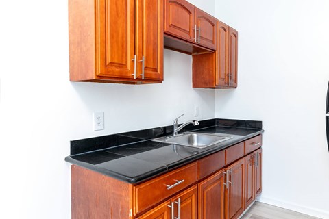 A kitchen with wooden cabinets and a black countertop.