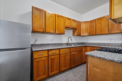 A kitchen with wooden cabinets and a granite countertop.
