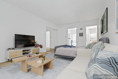 A living room with a television, a sofa, and a coffee table.