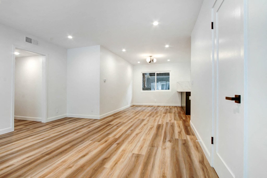 a living room with a hard wood floor and white walls