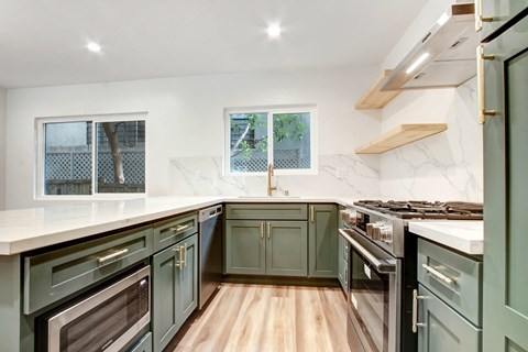 a kitchen with green cabinets and white counter tops