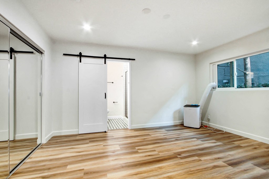 a room with a sliding glass door and a hard wood floor