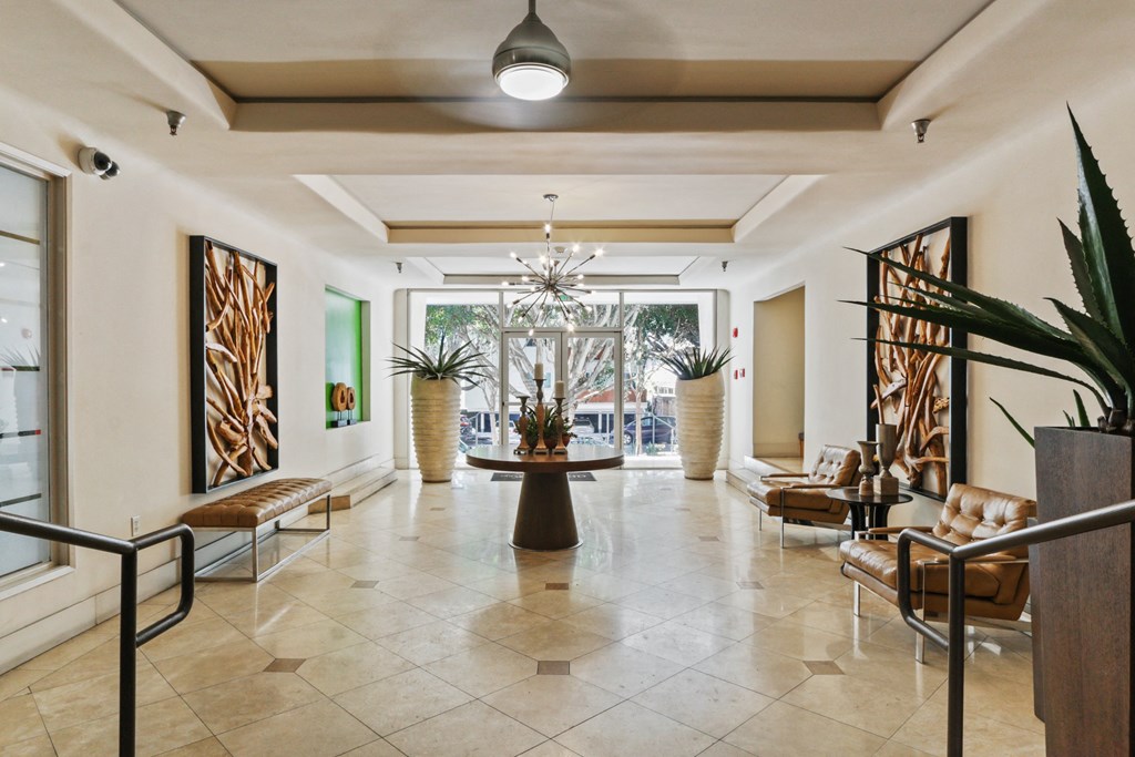 a lobby with chairs and a table and a chandelier