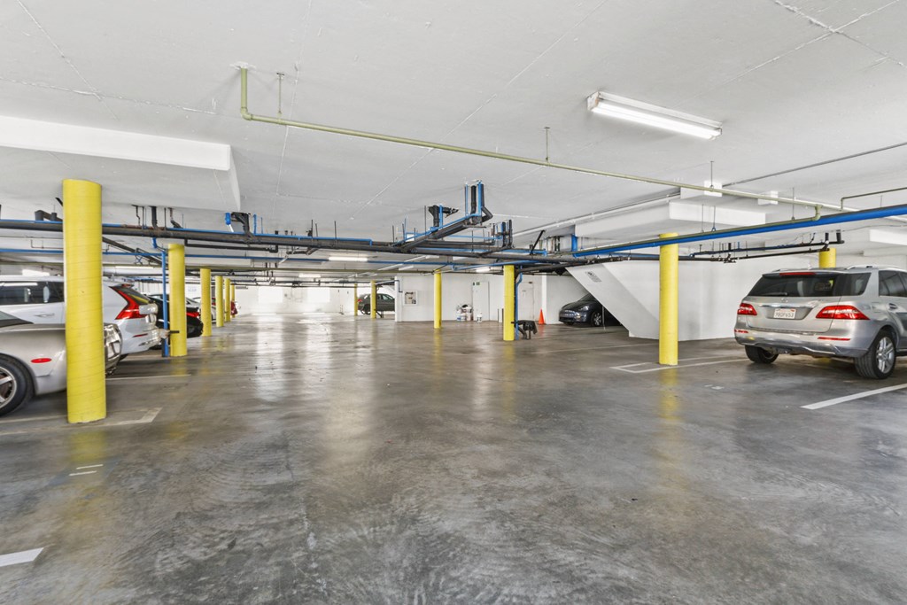 a parking garage with cars in it and yellow pillars