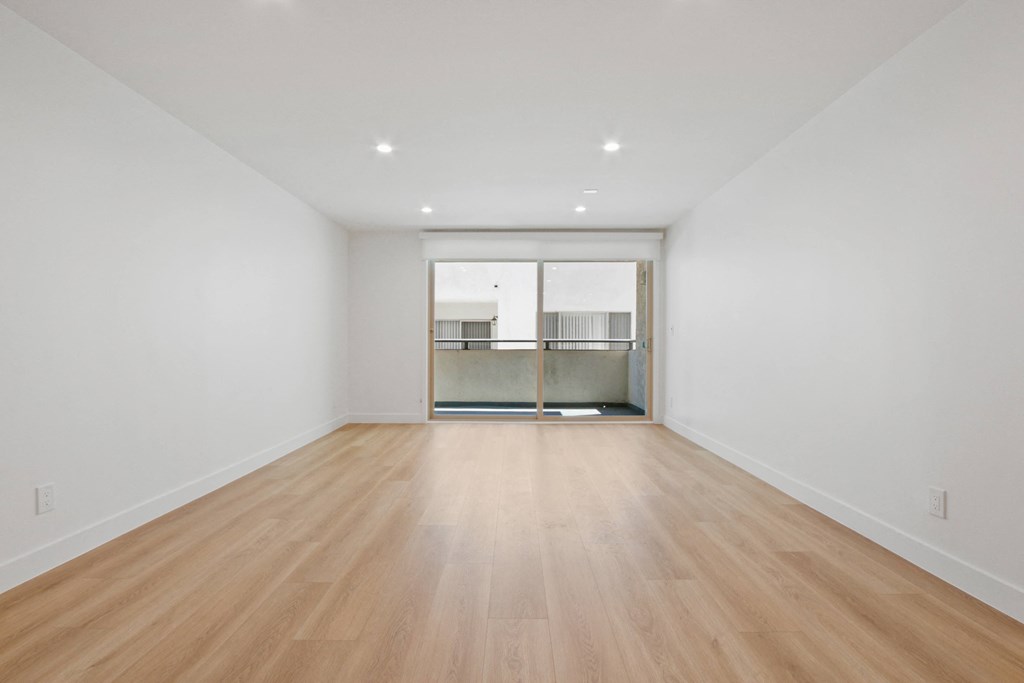 a living room with a hardwood floor and white walls