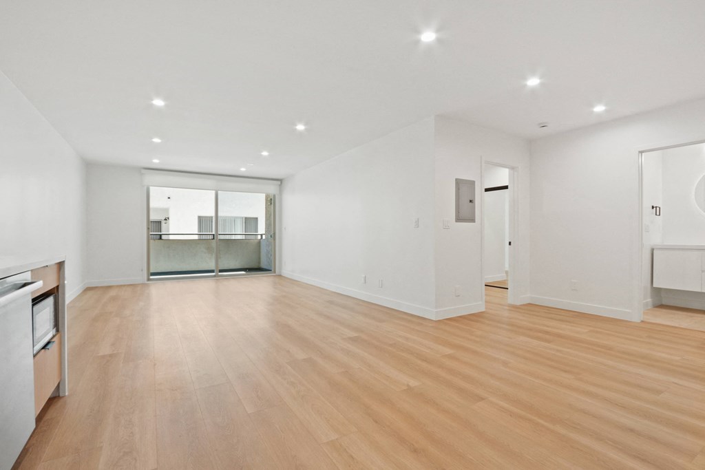 a living room with a hardwood floor and white walls