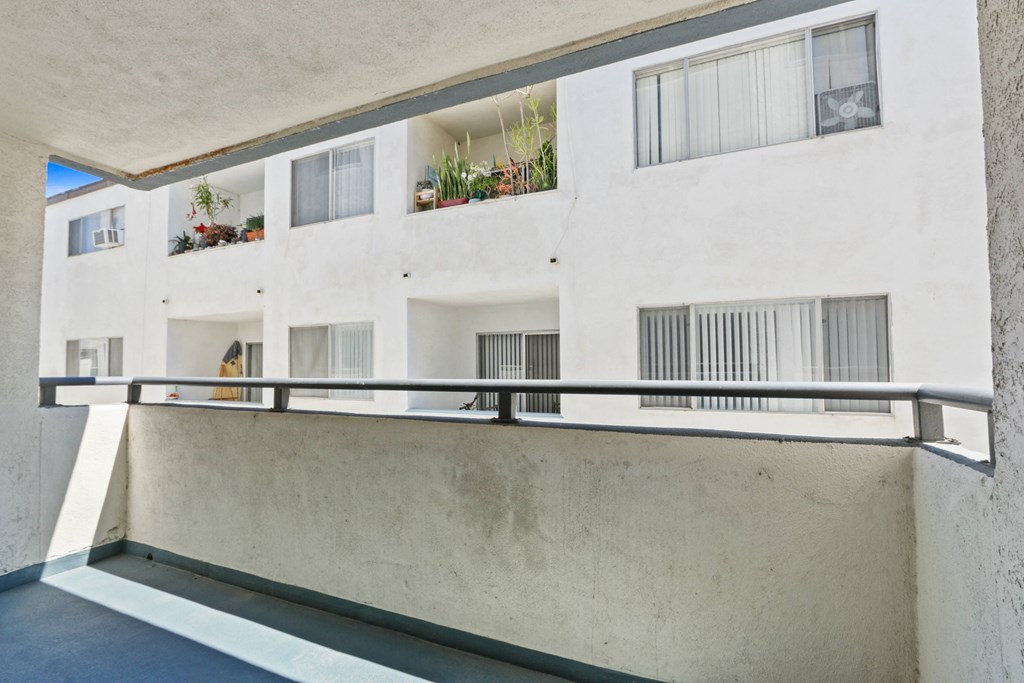 a white apartment building with a balcony and a railing