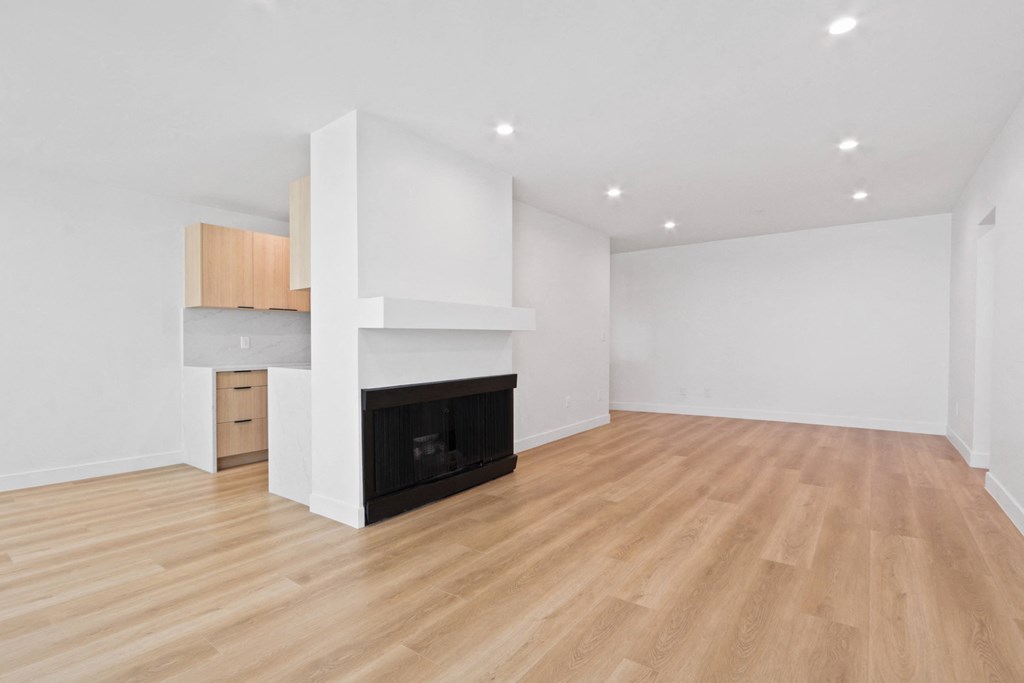 a living room with a fireplace and a wooden floor