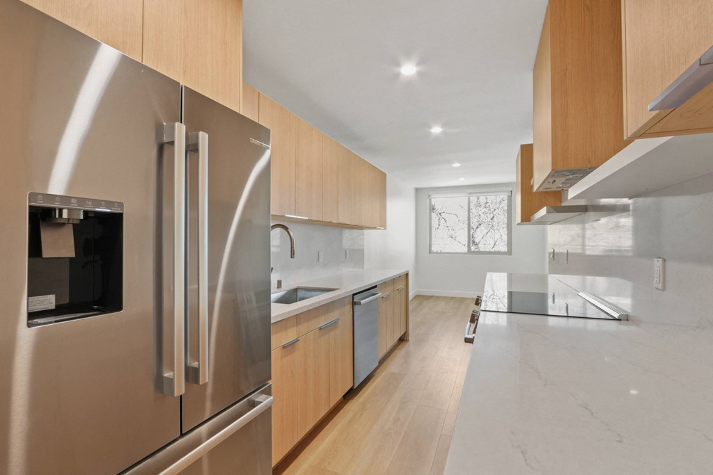 a kitchen with stainless steel appliances and wooden cabinets