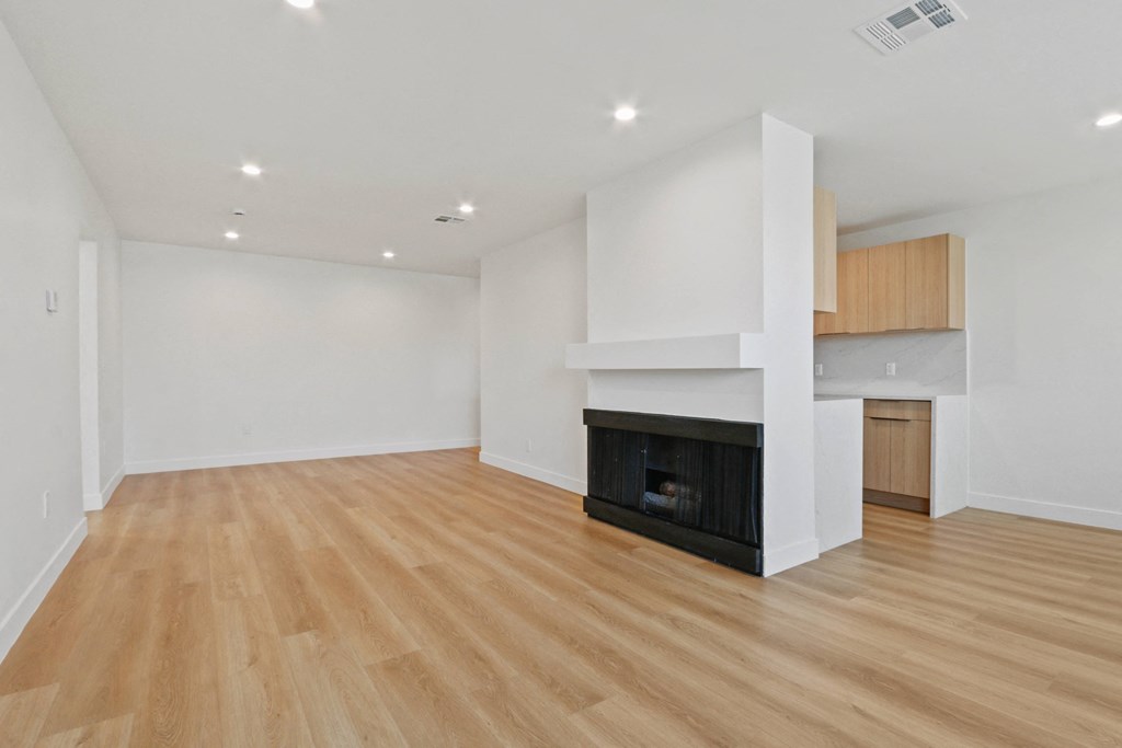 a living room with a fireplace and a wooden floor