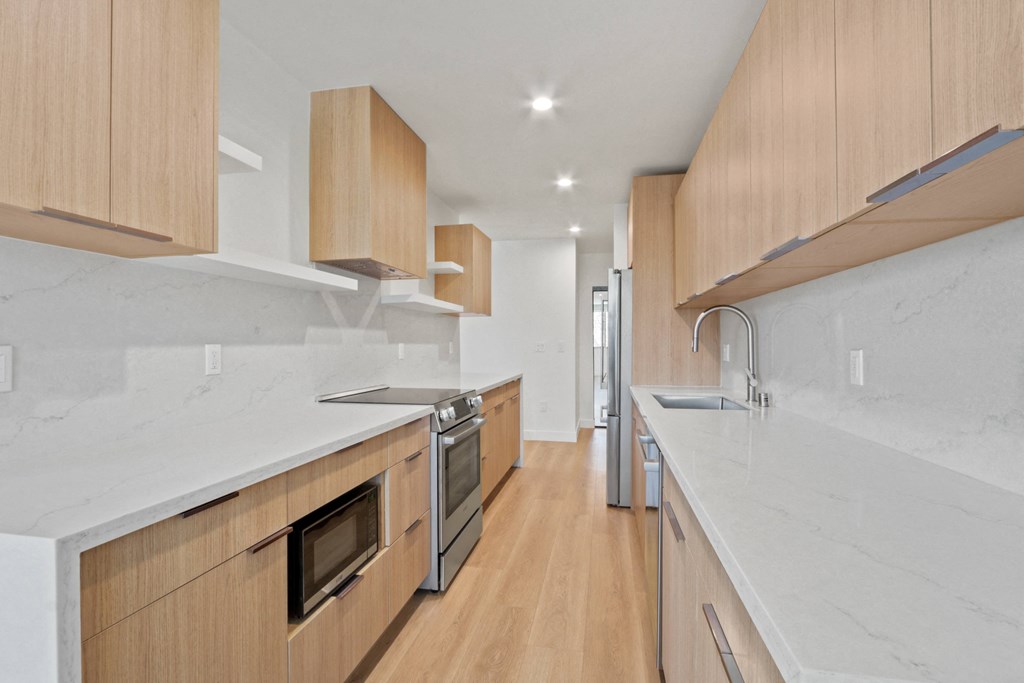a large kitchen with wooden cabinets and marble counter tops