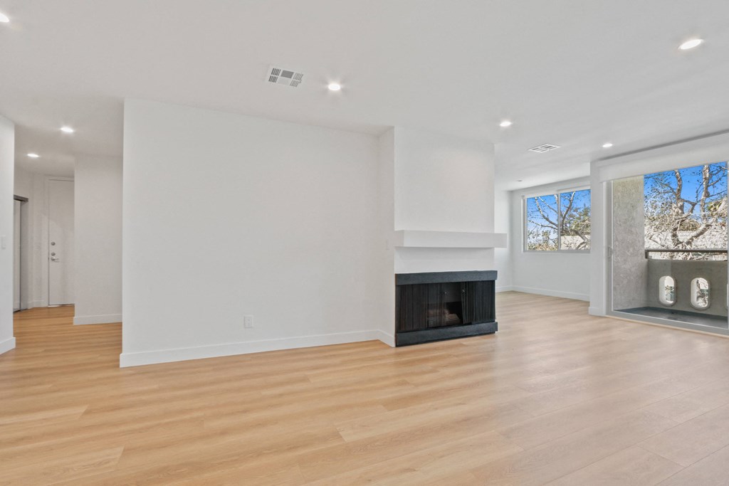 a living room with white walls and a fireplace