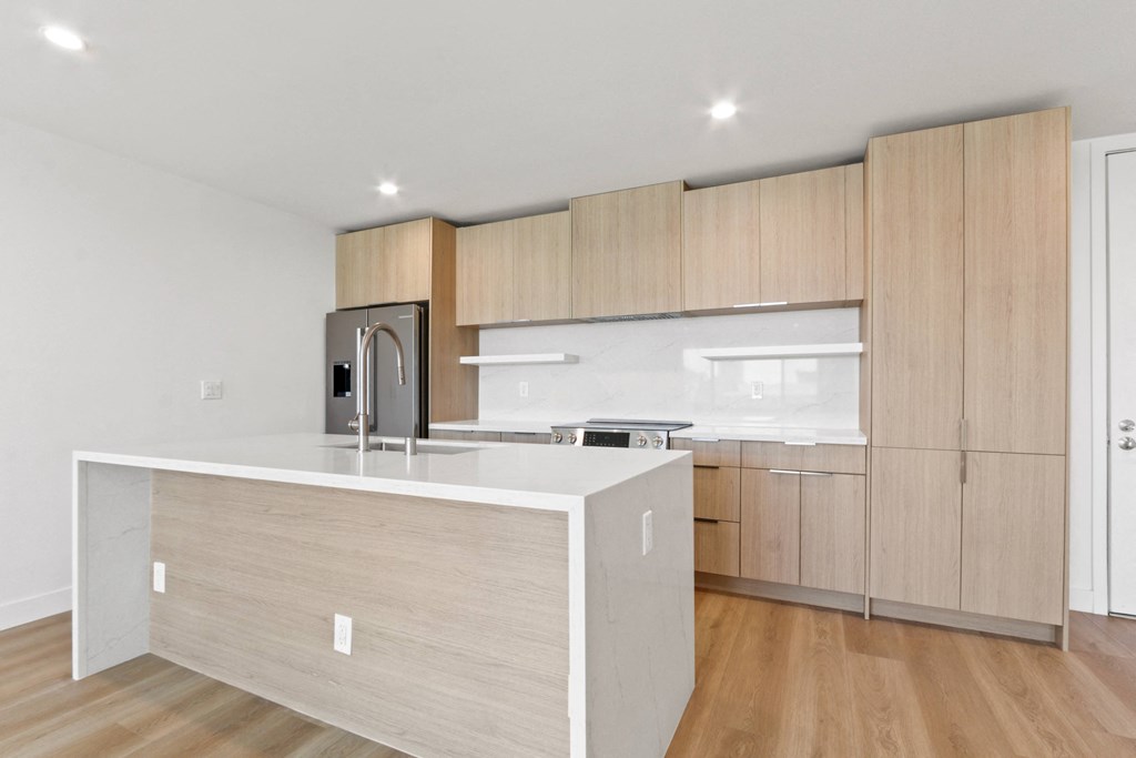 a kitchen with a large island and wooden cabinets
