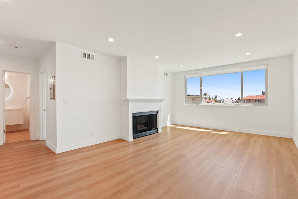 a living room with a fireplace and wooden floors