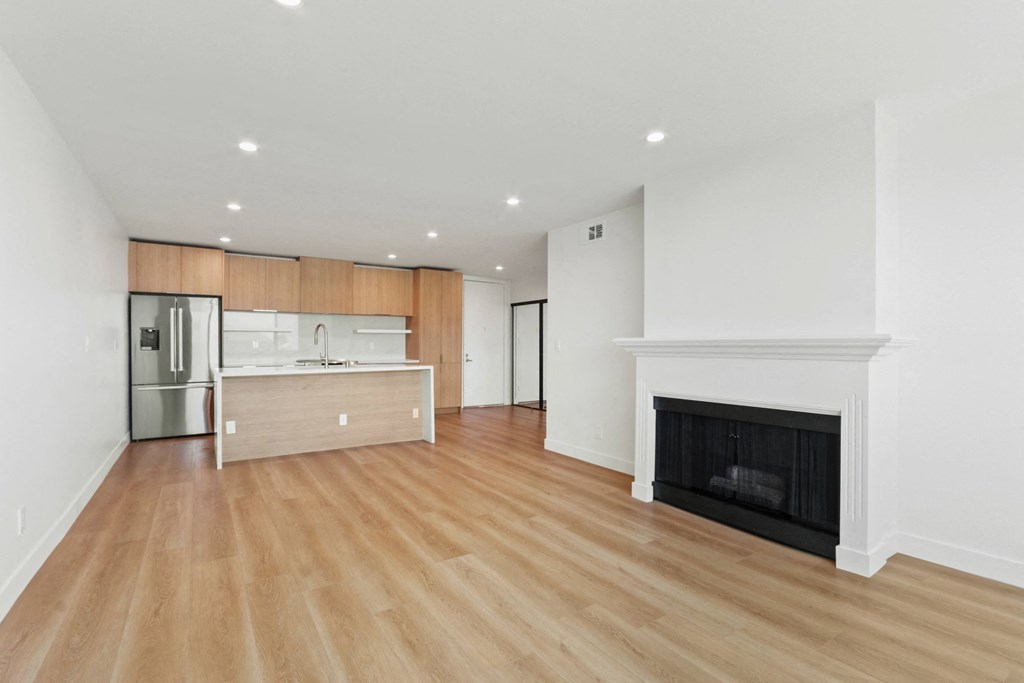 a living room with a fireplace and a kitchen
