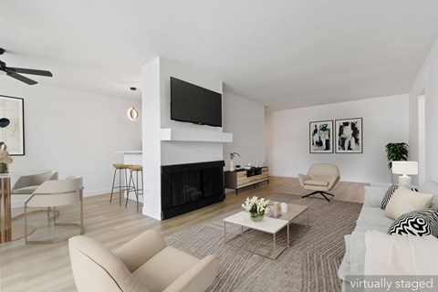 A living room with a fireplace and a television on the wall.