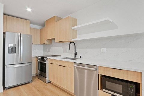 A modern kitchen with wooden cabinets and stainless steel appliances.