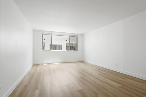 A room with a wooden floor and a large window.