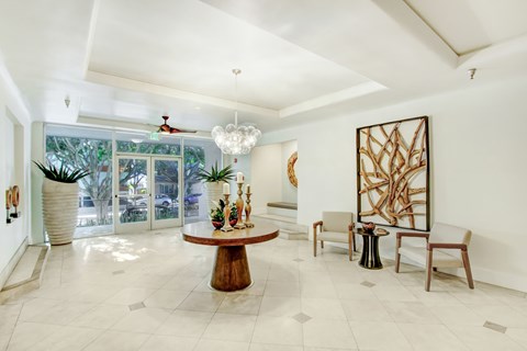 A modern living room with a wooden coffee table and a large abstract painting on the wall.