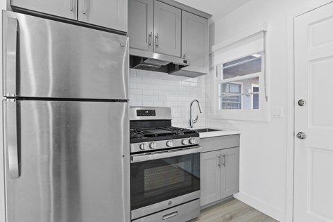 A modern kitchen with a stainless steel refrigerator and oven.