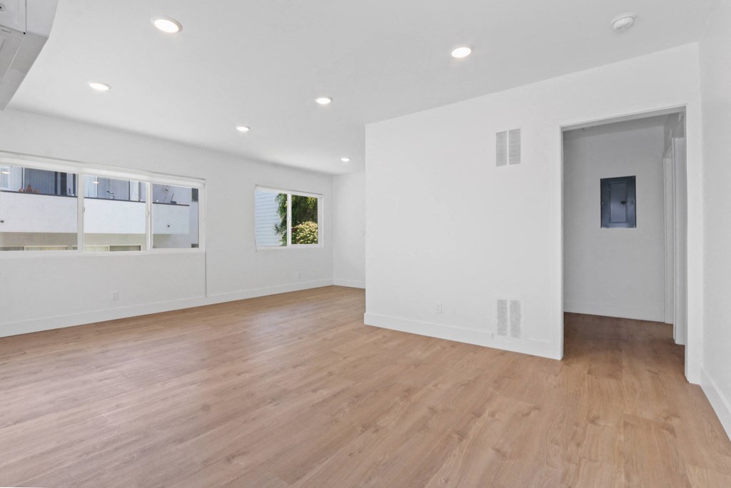 a living room with white walls and a wooden floor